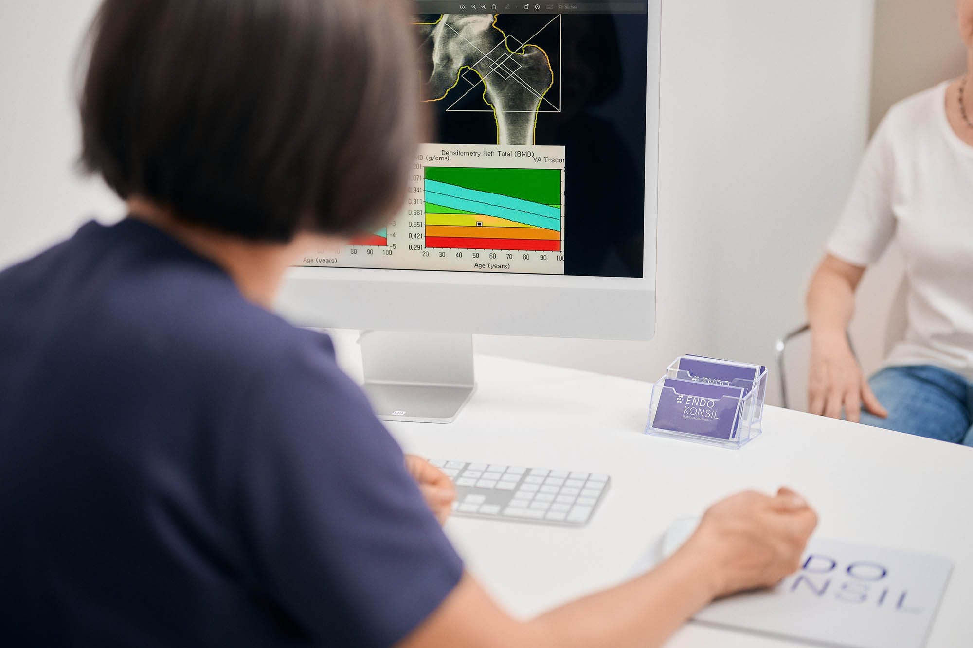 Eine Ärztin wertet die Knochendichtenmessung einer Patientin aus.